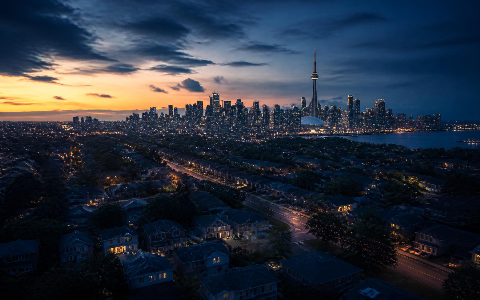 Aerial view of Greater Toronto Area homes at dusk with the downtown skyline behind